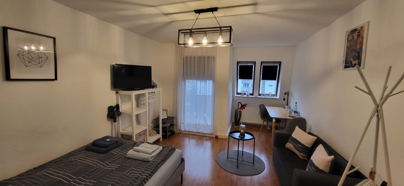 Eine helle, moderne Wohnzimmereinrichtung mit Sofa, Tisch und Fernseher. Eine helle, moderne Wohnzimmereinrichtung mit Sofa, Tisch und Fernseher.