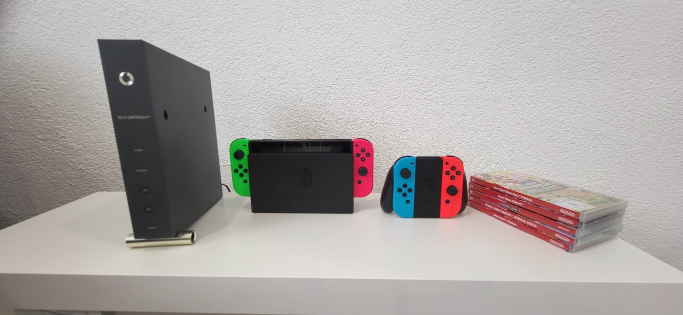 Schwarze Konsole mit Nintendo Switch und Joy-Cons in Neonfarben auf einem Tisch. Schwarze Konsole mit Nintendo Switch und Joy-Cons in Neonfarben auf einem Tisch.